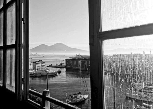 Fotografia in bianco e nero dove si vede il golfo di Napoli e il Vesuvio in fondo.